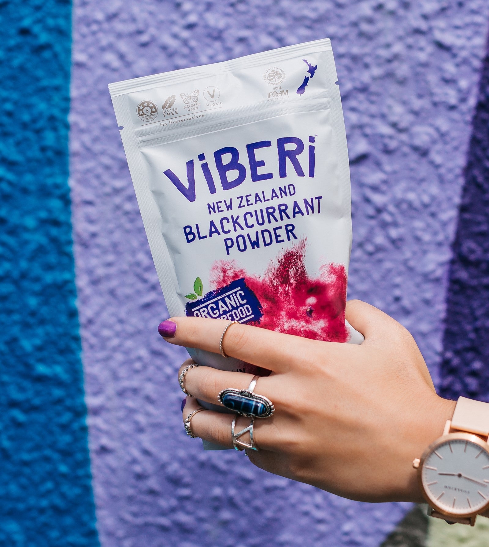 Hand holding packet of ViBERi Organic Blackcurrant Powder